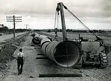 58-inch pipes between Palmer and Mannum. Photo taken February 1951. Man in foreground walking away from camera is Harold Bartholomaeus