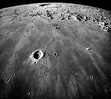 Southward looking oblique view of Mare Imbrium and Copernicus crater seen almost edge-on near the horizon with secondary elongated crater chains. 