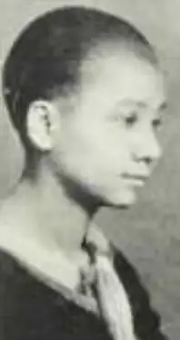 A young Black woman with light skin and very short dark hair, in 3/4 profile