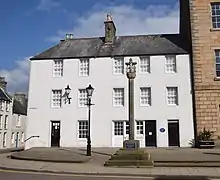 The town's mercat cross. The edge of the town house is on the right