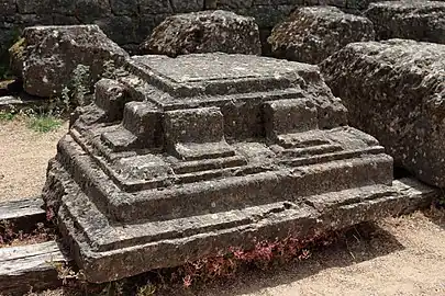 Photo of a carved corner stone on the floor.