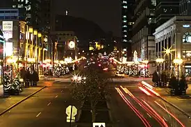 A view of McGill College Avenue in December, looking north. The Mount Royal Cross is visible in the background.