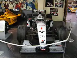 A McLaren MP4/14 on display at the Donington Collection. The car carries chassis number 4 and is in the state it crossed the line to win both the 1999 Japanese Grand Prix and the Formula One Drivers' Championship for its driver, Mika Häkkinen.