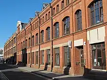 Three-storey, mostly brick building with glass windows.