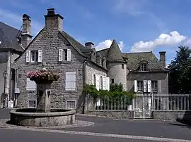 The fountain and a house in Menet