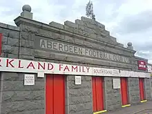 Photograph of one story facade with red doors