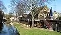 View along the banks of the Wandle, with the watermill at the rear