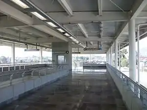 Picture of Tlaltenco's lobby, a mezzanine with access to the main island platform. The image features a hallway and an elevator shaft.