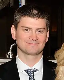 An approximately 35 year-old man looking at the camera.