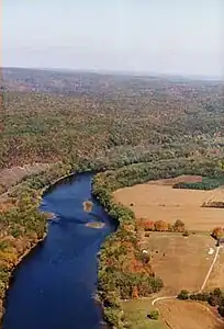 A placid river winds its way through farmland and forest.