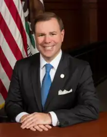 Mike Carroll, City Councilmember of Irvine California sitting at a desk.