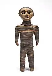 Bound wooden figure of a child, with open mouth, and real human eyes