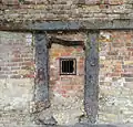 The hearth of the furnace, with the remains of the last failed firing showing as the yellowish mass at the bottom. Of interest are the hand impressions cast into the uprights of the hearth. A hole has been made to allow a view of the now emptied inside of the furnace