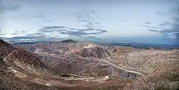 One of the active pits at the Morenci Mine. The horizontal shelves are the mining benches.  The fan-like slopes are leached material, dumped into mined-out portions of the pit.