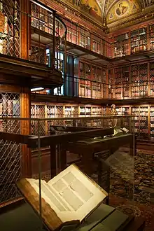 A glass case holds an open book in a library