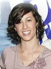 Woman smiling in front of a multi-coloured background