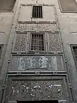 The decoration on the exterior wall above the mosque's rear entrance doors.