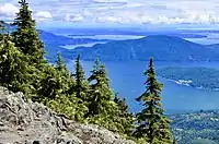 Summit of a mountain looking down onto lakes below, with trees on the summit