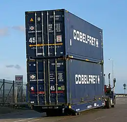 Two 45-foot 'High-cube' intermodal containers on a roll-on/roll-off (RoRo) tractor. The text in the yellow arrow on the top unit indicates its extra 2.50 metre (8'2½") width.