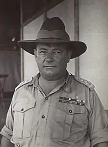 a black and white head and upper body photograph of a middle-aged man in uniform wearing a slouch hat with the brim down