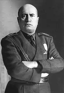 official portrait of Mussolini in uniform with crossed arms