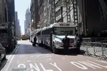 Four NYPD buses parked next to crowd control fences