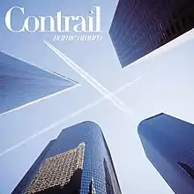 Skyscrapers with airplane contrails against a blue sky.