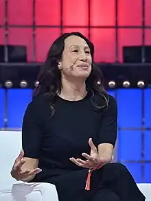 Naomi Gleit sitting and gesturing with her hands during a talk