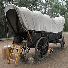 Narrow covered wagon of the type settlers used to bring goods and people west from Ontario via Winnipeg to Alberta, c. 1885