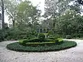 View of the gardens, ending in a small green lawn, surrounding the house