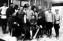 Photograph of Nestor Makhno and Halyna Kuzmenko seated, surrounded by other Makhnovists, while in a Polish internment camp