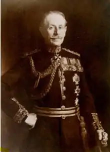 Sir Neville Chamberlain, aged about 60, with grey hair and moustache, in full dress uniform bearing several decorations.