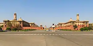 Vijay Chowk with North and South Block in the backdrop. As one looks at the Raisina Hill buildings from Vijay Chowk, the Rashtrapati Bhavan disappears and only its dome is visible.