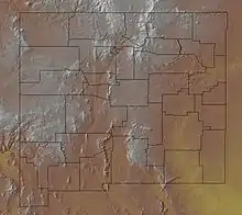 A map of a state's terrain, with brown and white colors representing higher elevations, and yellow and green colors representing lower elevations. County borders are also shown on the map.