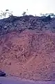 Soft nickel limonite below a hard layer of laterite on parent ultramafic rock. Yate, New Caledonia