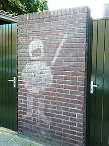 Stencil on wall of police officer with shield and baton