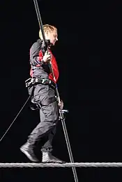 A man in black and red clothing on a tightrope