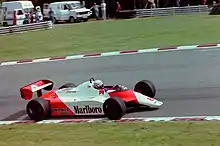 Sideview of a red-and-white McLaren racing car during a race