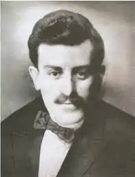 Black and white photograph of a young Pontian man with a mustache and bowtie. He faces the camera.