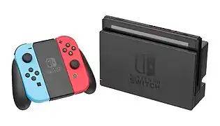 A Nintendo Switch in docked mode with Neon Blue & Neon Red Joy-Con controllers in grip