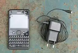 Nokia Asha 210 with Facebook button and French charger.