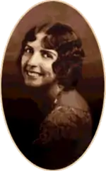 A studio photograph of a young woman looking over her shoulder.