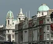 View upwards of street buildings with green domed roofs