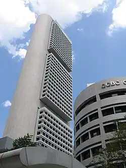 Ground level view of a box-like building with rounded, windowless side exteriors