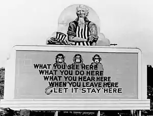 Billboard reading "What you see here / what you do here / what you hear here / when you leave here / let it stay here", with three wise monkeys to demonstrate "see no evil, hear no evil, speak no evil."