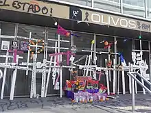 Multiple crosses and candles are located at the entrance of the metro station.