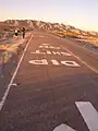 The markings on the other side of the road with only the mountains to the north in the background