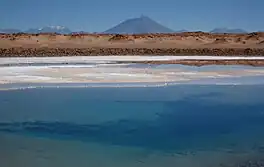 Photo of a blue pond with a mountain rising behind