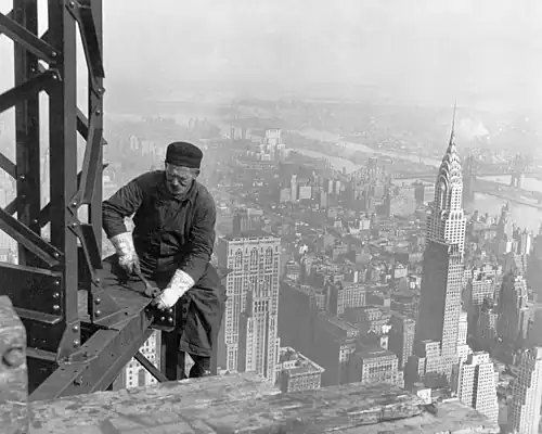 Image 20A workman helps raise the Empire State Building 25 floors higher than the Chrysler Building (at right), as seen in 1931. (from History of New York City (1898–1945))