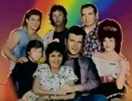 The show's characters posing for a group photo in front of a rainbow background.